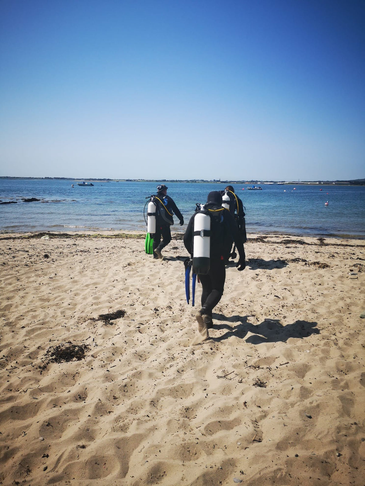 Divers heading towards the water for a shore dive